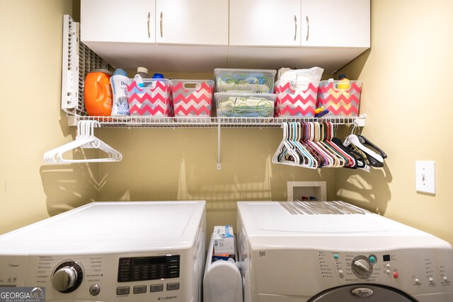 laundry area featuring independent washer and dryer and cabinets