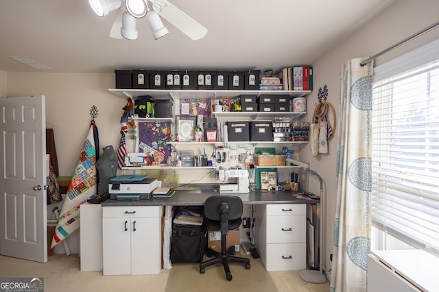 carpeted office space with ceiling fan