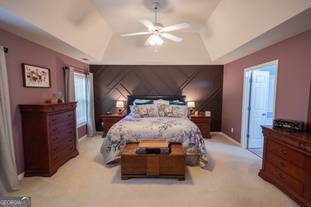 bedroom featuring ceiling fan, a tray ceiling, and light colored carpet