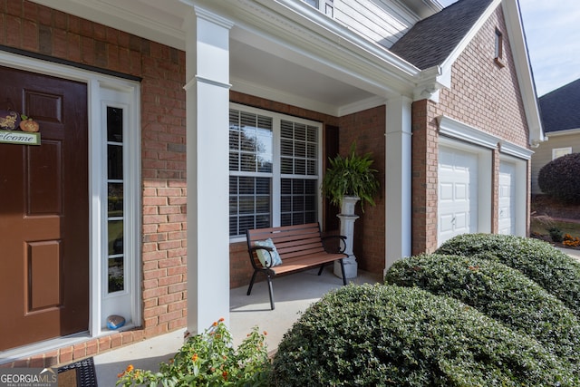 doorway to property featuring a porch and a garage