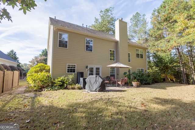 rear view of property with a patio and a yard