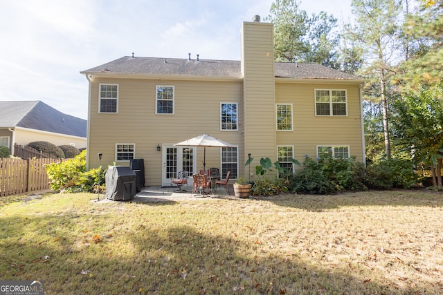 back of house featuring a patio area and a lawn