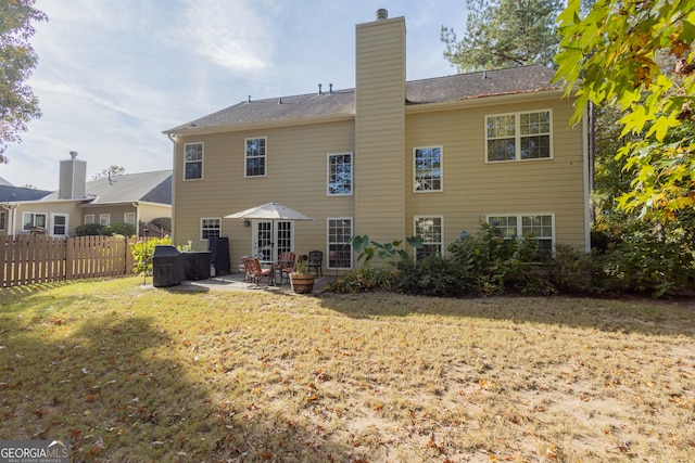 back of property featuring a yard and a patio area