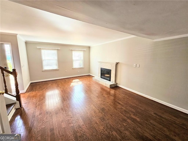 unfurnished living room with crown molding and dark hardwood / wood-style floors