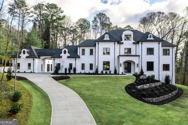 french country home featuring a front lawn