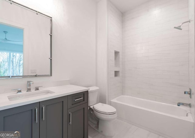 full bathroom featuring toilet, tiled shower / bath, and vanity