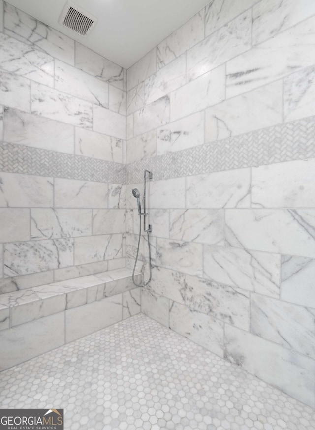 interior details featuring tiled shower