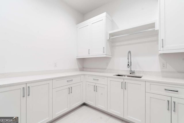 kitchen featuring white cabinetry and sink