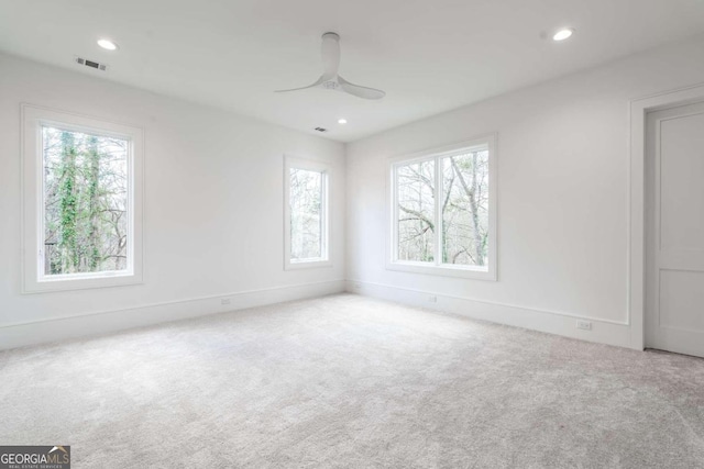 carpeted spare room with ceiling fan and a healthy amount of sunlight