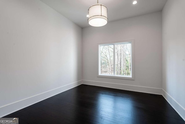 unfurnished room with dark wood-type flooring