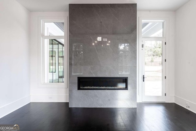 interior space with dark wood-type flooring and a tiled fireplace