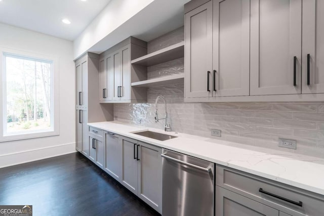 kitchen with light stone countertops, sink, dishwasher, gray cabinets, and dark hardwood / wood-style floors