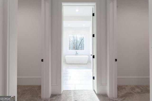 hallway with sink and light carpet