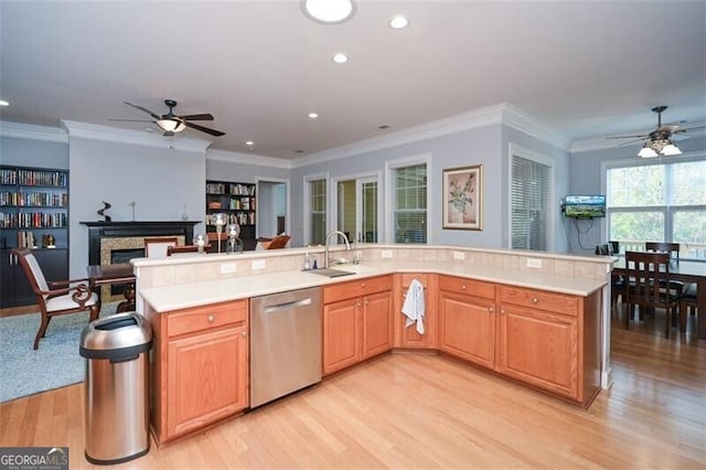 kitchen with crown molding, stainless steel dishwasher, and light wood-type flooring