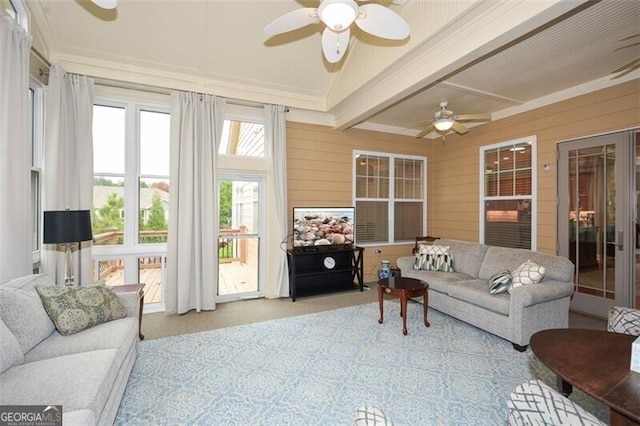 sunroom with ceiling fan and beam ceiling