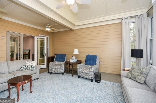 sunroom / solarium featuring beamed ceiling and ceiling fan