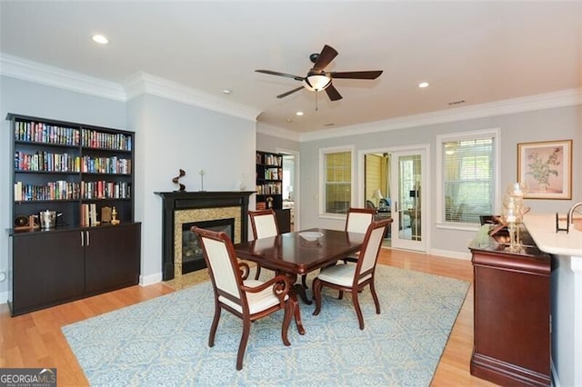 dining room with crown molding, light hardwood / wood-style flooring, and ceiling fan