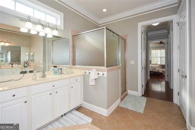 bathroom with a shower with door, tile patterned flooring, crown molding, vanity, and ceiling fan