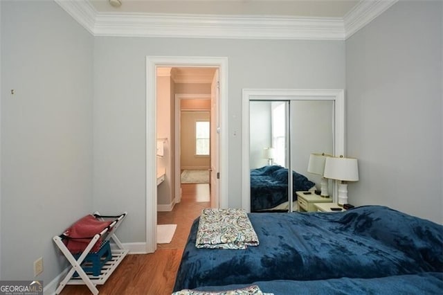 bedroom with a closet, ornamental molding, and wood-type flooring