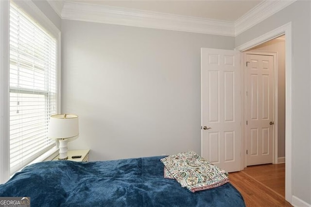 bedroom with hardwood / wood-style floors and crown molding