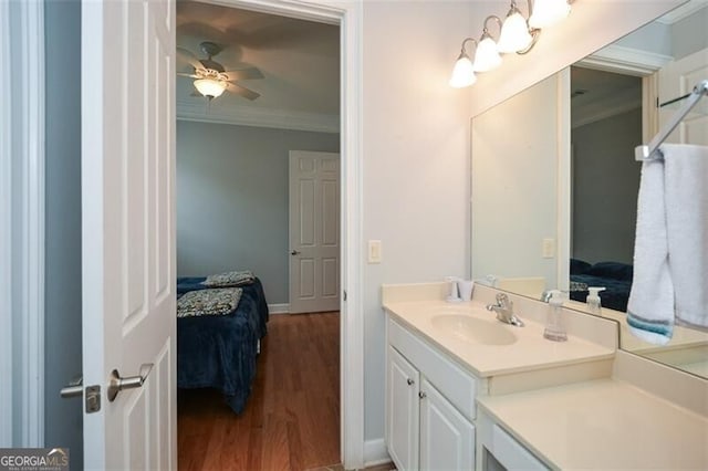 bathroom featuring vanity, hardwood / wood-style floors, ornamental molding, and ceiling fan