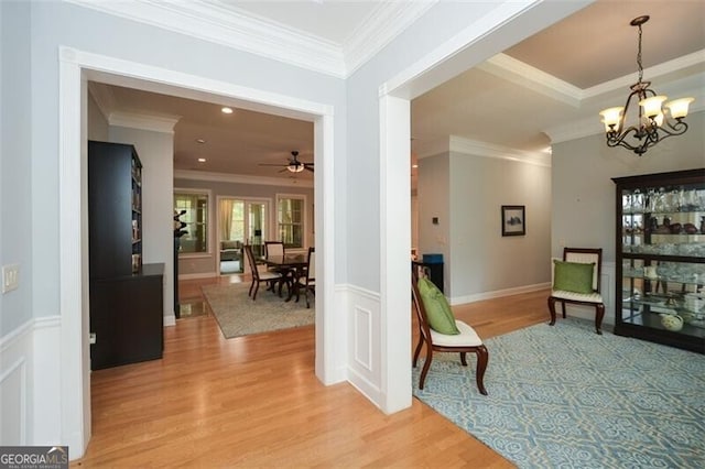 hall with crown molding, a chandelier, and light wood-type flooring