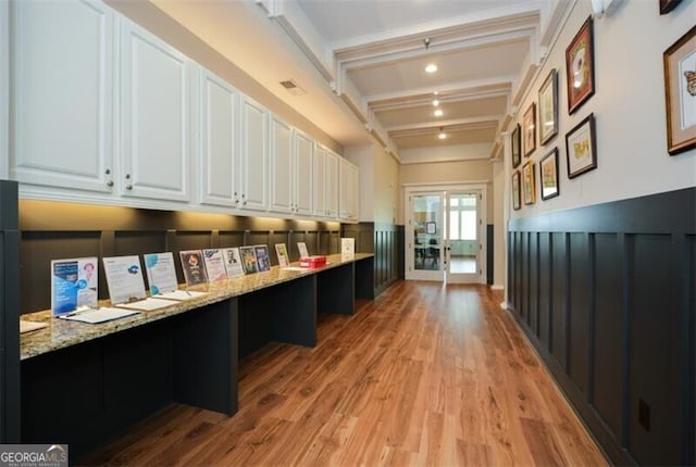 interior space with beamed ceiling and light hardwood / wood-style flooring