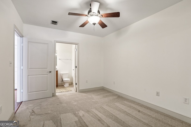 unfurnished bedroom with a walk in closet, light colored carpet, and ensuite bathroom