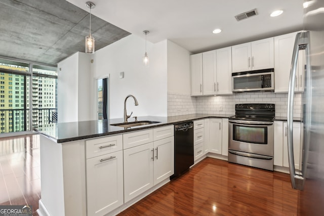 kitchen featuring kitchen peninsula, hanging light fixtures, sink, white cabinetry, and appliances with stainless steel finishes