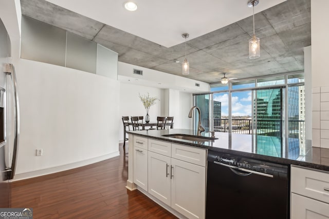 kitchen featuring dark wood-type flooring, black dishwasher, white cabinets, sink, and decorative light fixtures