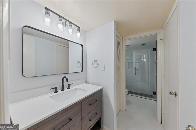 bathroom with vanity, a shower with shower door, and toilet