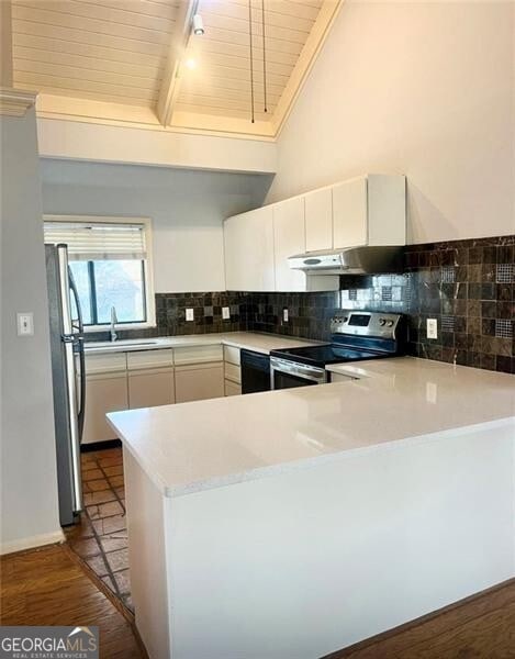 kitchen featuring beam ceiling, stainless steel appliances, tasteful backsplash, kitchen peninsula, and white cabinets