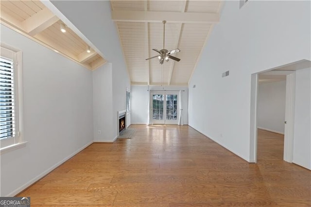 unfurnished living room featuring ceiling fan, high vaulted ceiling, wooden ceiling, beamed ceiling, and light hardwood / wood-style floors