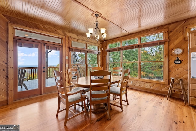 dining space featuring french doors, a wealth of natural light, and wood walls