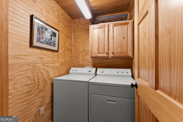 washroom featuring wood walls, cabinets, wood ceiling, and washer and dryer