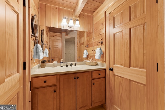 bathroom with vanity, wooden walls, beam ceiling, and wooden ceiling