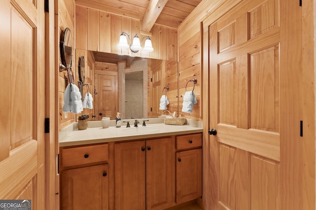 bathroom featuring beamed ceiling, vanity, wooden ceiling, and wood walls