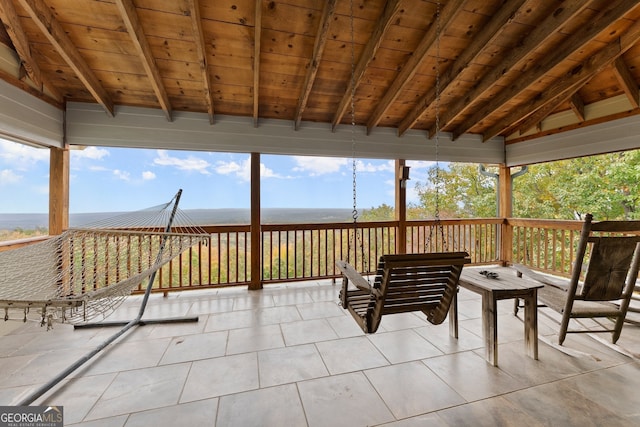 sunroom featuring lofted ceiling with beams and wooden ceiling