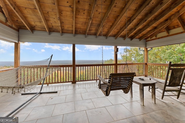 sunroom featuring wood ceiling, plenty of natural light, and lofted ceiling with beams