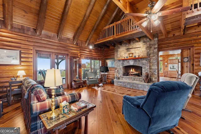 living room with a fireplace, light wood-type flooring, beamed ceiling, wooden ceiling, and log walls