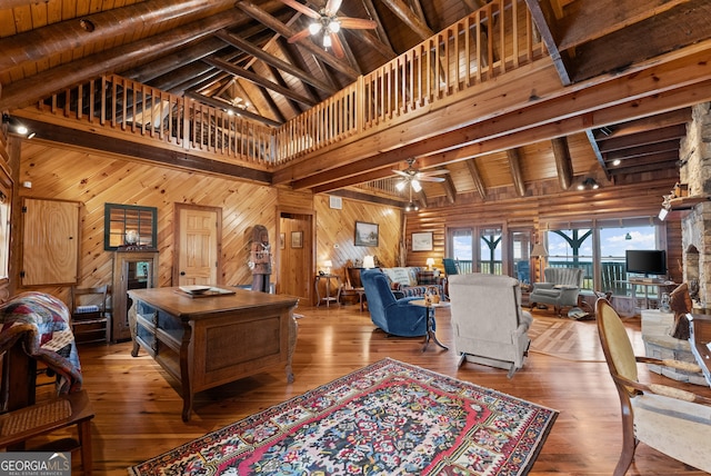 living room featuring beam ceiling, high vaulted ceiling, wood walls, hardwood / wood-style floors, and wooden ceiling