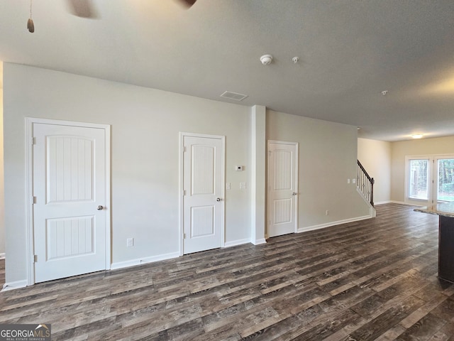 unfurnished room featuring ceiling fan, dark hardwood / wood-style flooring, and a textured ceiling