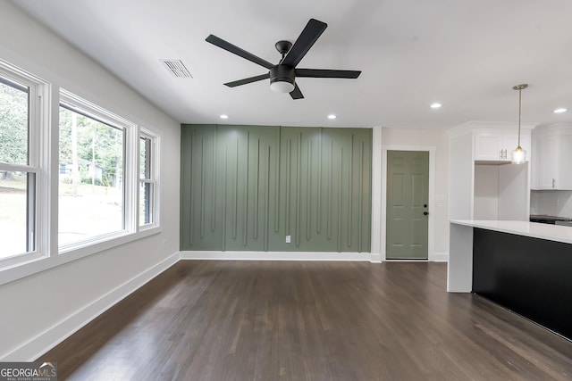 unfurnished living room featuring dark hardwood / wood-style floors and ceiling fan