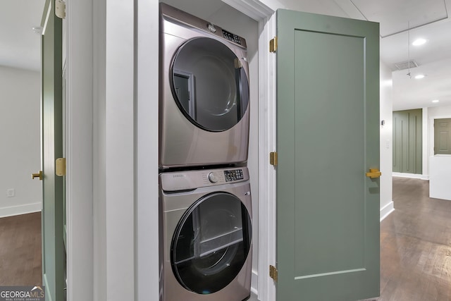 clothes washing area with hardwood / wood-style flooring and stacked washer and dryer