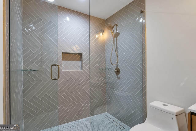 bathroom featuring vanity, toilet, and a shower with shower door