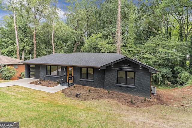 view of front of home featuring central AC and a front lawn