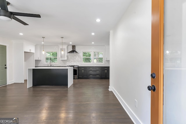 kitchen with wall chimney exhaust hood, dark wood-type flooring, pendant lighting, a center island, and white cabinetry