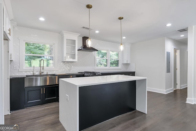 kitchen featuring white cabinets, wall chimney exhaust hood, a healthy amount of sunlight, and dark wood-type flooring