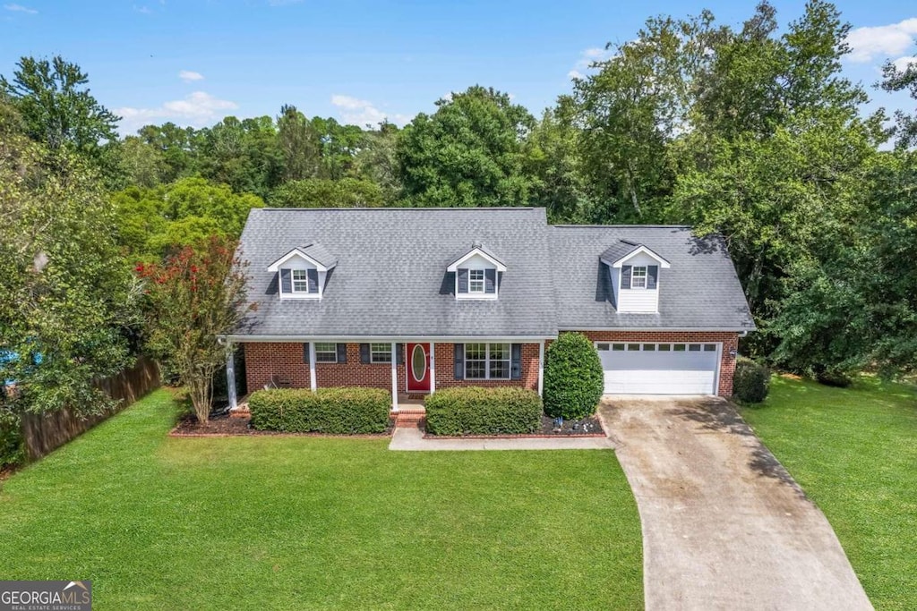 new england style home with a front yard and a garage