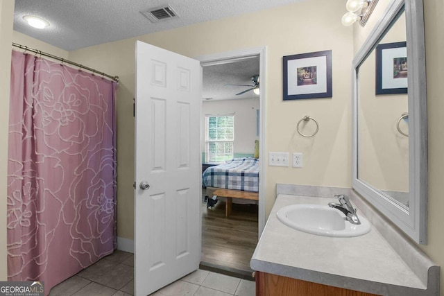 bathroom featuring vanity, ceiling fan, tile patterned floors, and a textured ceiling